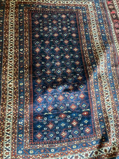 null Oriental carpet with a navy blue background decorated with stylized flowers,...