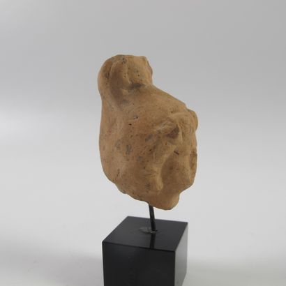 null Female head in terracotta. L 4.5cm (L 7.5cm with the base). Hellenistic period,...