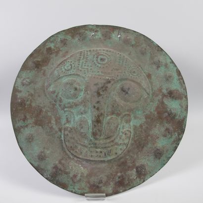 null Votive plate in embossed copper decorated with a feline deity. Diameter 29cm....