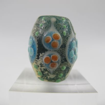 null Ovoid pearl with 9 symbolic ocelli. Blue-green glass paste with polychrome decoration....