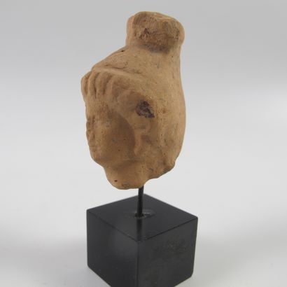 null Tête féminine en terre cuite. L 4.5cm (L 7.5cm avec le socle). Epoque hellénistique,...