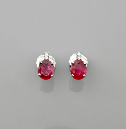 null White gold earrings, each with two diamonds above an oval ruby, total approx....