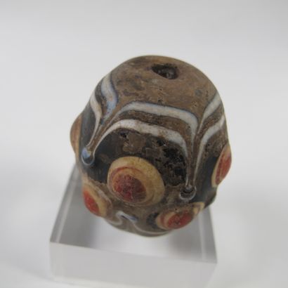 null Asia. China. Large mamelonned bead in a barrel with 10 symbolic ocelli. Glass...