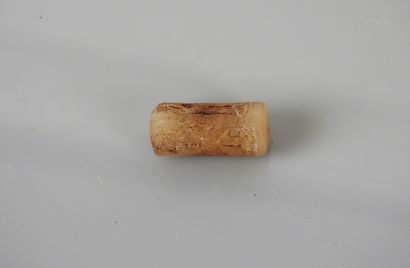 null White stone cylinder bead, decorated with a cult scene in intercession before...