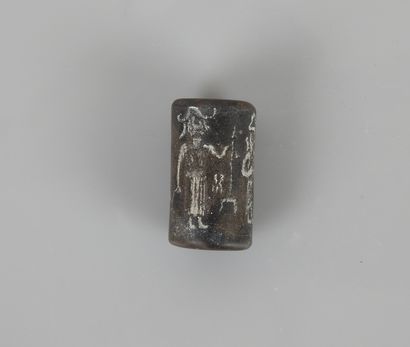 null Black stone cylinder bead representing a cult scene between man and animals.

Circa...