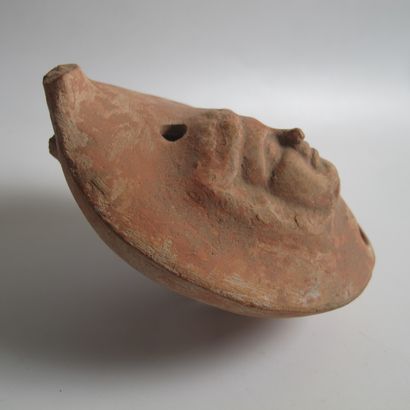 null Oil lamp decorated with a mask of Isis. Terracotta. L 12cm. As is (handle missing)....