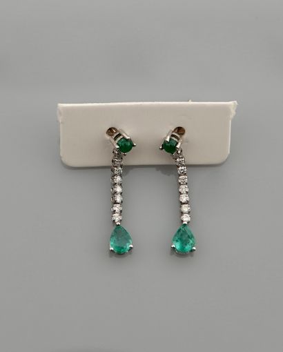 null Earrings in white gold, 750 MM, adorned with diamonds bearing a pear-cut emerald...