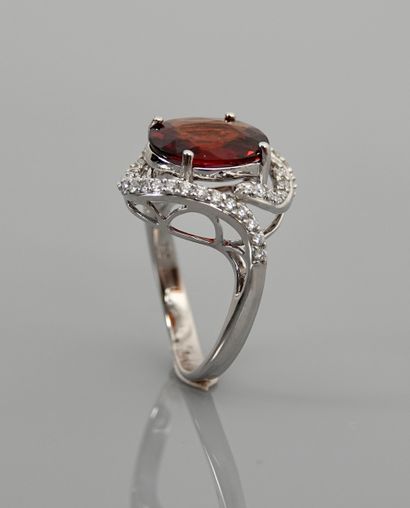 null White gold ring, 750 MM, set with an oval spessartite (orange garnet) weighing...