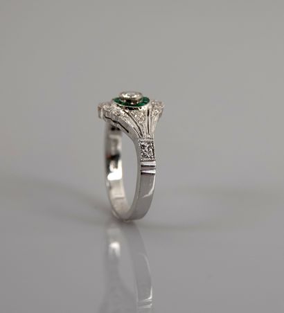 null Ring in white gold, 750 MM, centered on a diamond hemmed with calibrated emeralds...