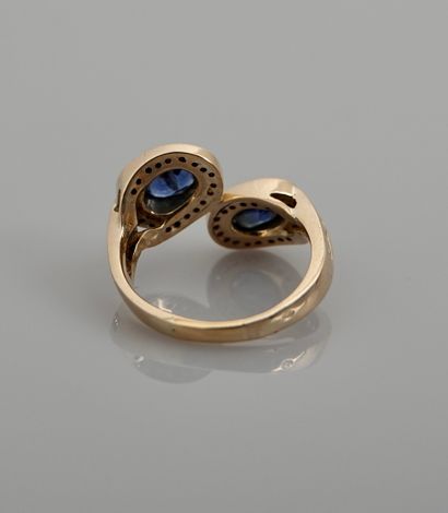 null Yellow gold cross ring, 750 MM, set with two oval sapphires each hemmed with...
