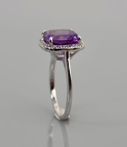null White gold ring, 750 MM, set with a cushion-cut amethyst hemmed with diamonds,...