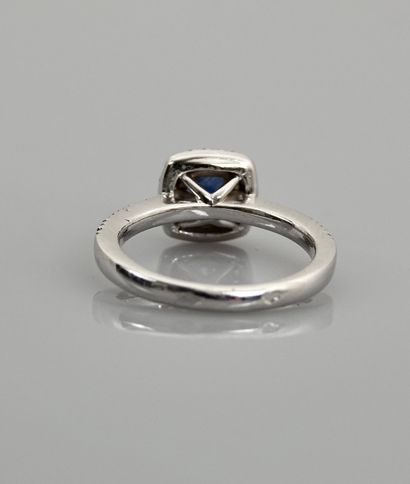 null White gold ring, 750 MM, set with a cushion-cut sapphire in a row of diamonds,...
