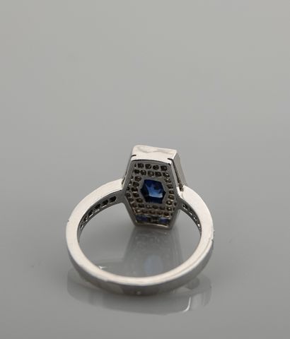 null Bague dessinant un plateau Tonneau en or gris, 750 MM, centré d'un saphir entouré...