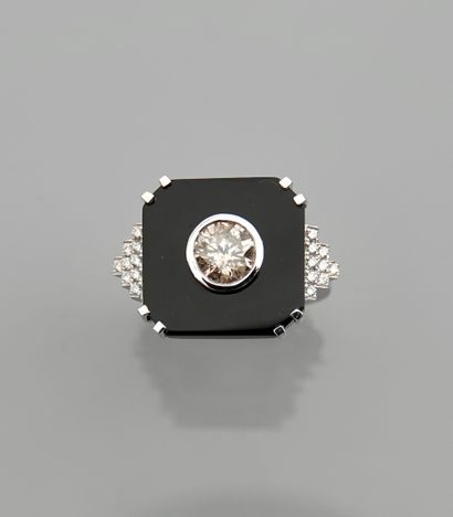 null White gold ring, 750 MM, set with a cut onyx centered with a diamond weighing...