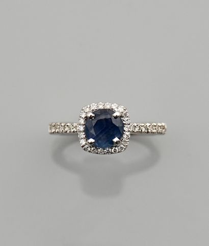 null White gold ring, 750 MM, set with a cushion-cut sapphire in a row of diamonds,...