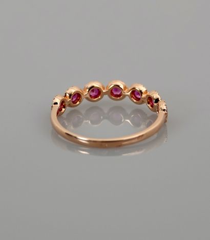 null Half wedding band in pink gold, 750 MM, centered with seven rubies surrounded...