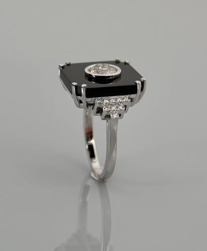 null White gold ring, 750 MM, set with a cut onyx centered with a diamond weighing...