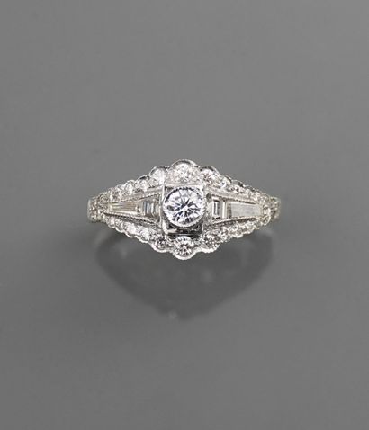 null Flat ring in white gold, 750 MM, set with round diamonds around baguette-cut...