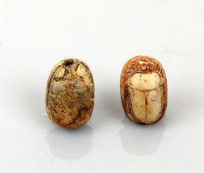 null Two scarab beads inscribed with hieroglyphs and a scene with a character

Frit...