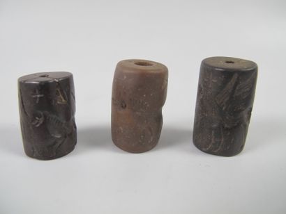null Three cylinder-seal beads engraved in intaglio with stags, griffins, wolf and...