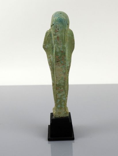 null Oushebti of an olive green color carrying the aratorial instruments, inscribed...