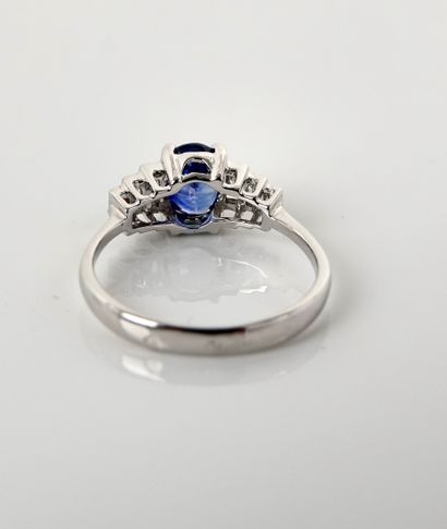 null White gold ring, 750 MM, set with an oval sapphire weighing 1.20, with six baguette...