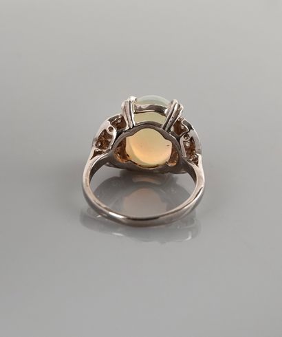 null Ring in white gold, 750 MM, set with a cabochon opal between two patterns covered...