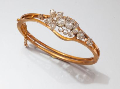 null Bracelet rigide ouvrant en or jaune ajouré orné d'un motif floral serti de diamants...