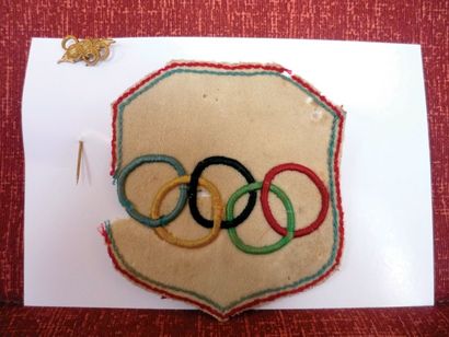 null Deux pièces: a) écusson olympique en tissus avec liséré tricolore et anneaux...