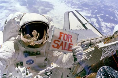 NASA, 1984 L’astronaute Dale Gardner brandit une notice de mise en vente après que...