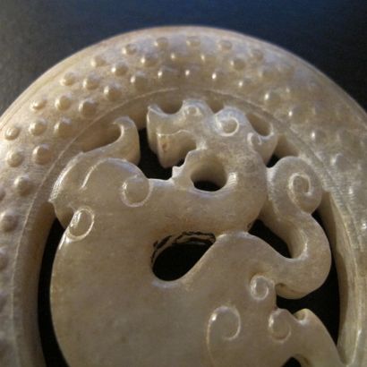 null Médaillon ovale ajouré au dragon,à décor de grains qui germent,symboles de renaissance.Jade.L :8,5cm.

Chine...