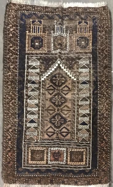 null Caucase. Petit tapis fond brun à décor de mihrab dans des bordures géométriques.

140...