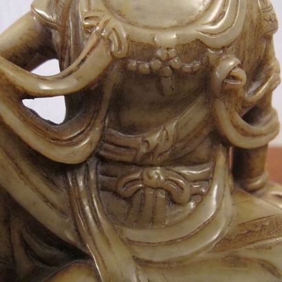 null Statuette de GuanYin assise en majesté sur le lotus. Stéatite ambrée. L 18.5cm....