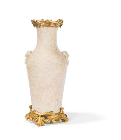 null Vase en porcelaine Chine craquelée à monture de bronze doré ajourée et feuillagée.
Style...