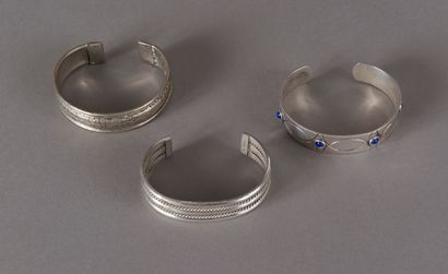 null Three open half-bracelets in silver, decorated with twists, cracks or blue stones...