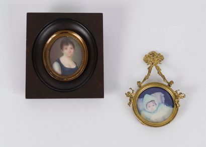 null A small brass hanging frame, round shape, decorated with two cherubs, held by...