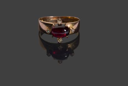 null 
Pink gold band ring set with a garnet cabochon surrounded by four half-pearls,...