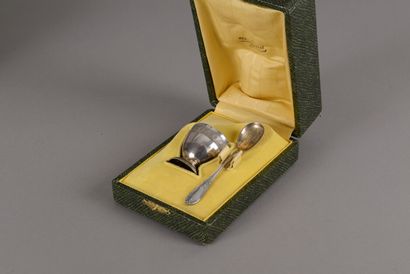 An egg cup and its spoon with egg in silver...
