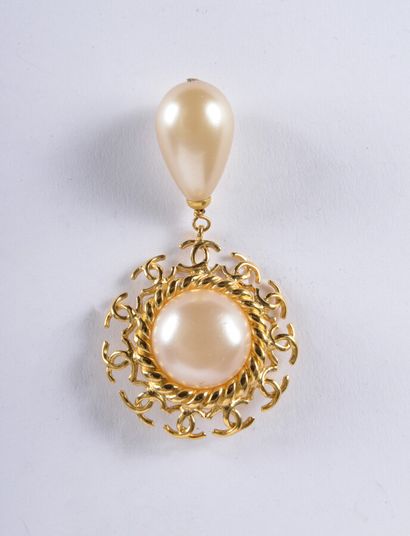 null Chanel, broche en métal doré ornée d'un demi-perle fantaisie centrale entourée...