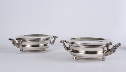 null A pair of four-legged silver plated plate warmers, the handles with foliage,...