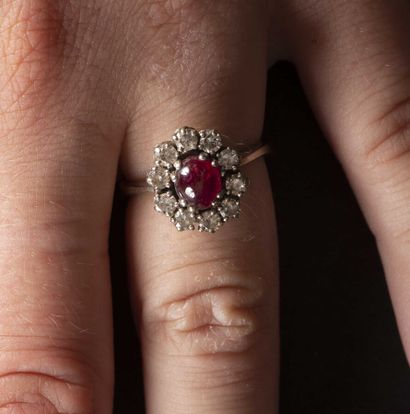 null Ring in gold 750 thousandth set with a ruby cabochon surrounded by ten diamonds...