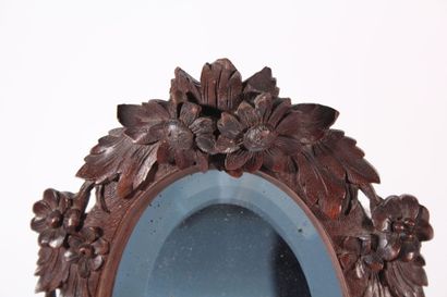 null Oval mirror, base and frame in carved wood with foliage and flowers in the Black...