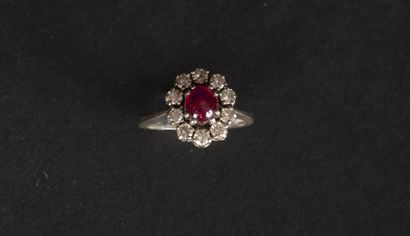 null Ring in gold 750 thousandth set with a ruby cabochon surrounded by ten diamonds...