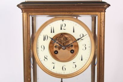 null Brass and bevelled glass clock, enamelled dial, mercury balance 

End of the...