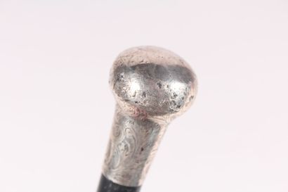 null English cane, the shaft in black wood, the knob in silver chased with flowers,...