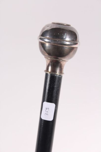 null Cane, the shaft in black wood, the round pommel circled in English silver. Length...