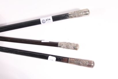 Three canes in black painted wood, knob in...