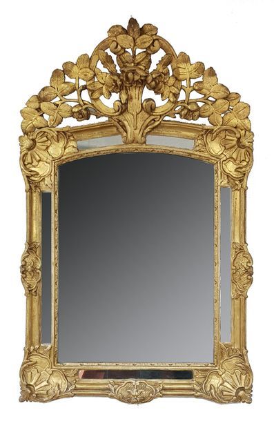 null Miroir à parecloses et fronton en bois sculpté, stuqué et doré à décor d'un...