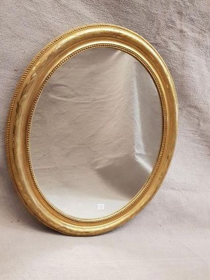 null Miroir ovale en bois mouluré à frise de perles et doré. XXe siècle. 62 x 52...