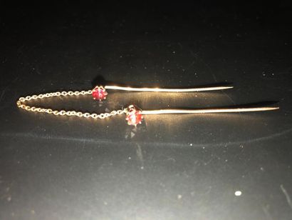 null Two 18K (750°/°°) yellow gold tie pins set with two garnets and linked by a...